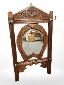 A stained pine coat rack with horse shoe shaped central mirror, length 90 cm.