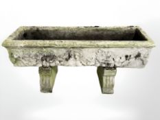 A weathered concrete rectangular raised planter,