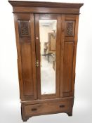 An Edwardian carved walnut single mirror door wardrobe, 108 cm W x 46 cm D x 206 cm H.