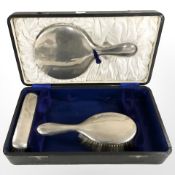 A silver mounted part dressing table set, comprising of two brushes and a hand mirror,