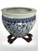 A reproduction Chinese blue and white porcelain fish bowl planter on stand, height 36 cm.