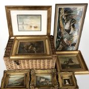A wicker hamper containing ornate gilt framed prints and a needlework tapestry.