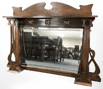 An Art Nouveau walnut over mantel mirror with copper butterfly inset motifs,