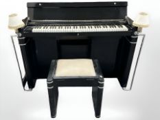 An Eavestaff ebonised mini piano with twin lamp sconces, with key and matching stool,