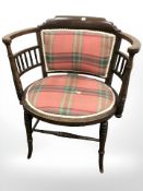 An Edwardian walnut oval armchair.