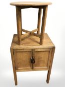 An oak circular occasional table and a double door record cabinet.