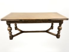 A reproduction carved oak extending refectory dining table, with pullout leaves,