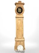 A 19th century continental stripped pine longcase clock with pendulum and weights, height 214 cm.