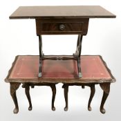 A nest of three tooled leather inset tables and a small drop leaf table.