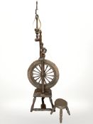 A 19th century spinning wheel and a small spinning stool.