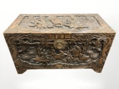 An oriental heavily carved camphor wood blanket chest, width 112 cm.