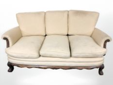 A 1920's carved mahogany bergere three piece lounge suite comprising of three seater settee and