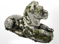 A weathered concrete recumbent garden lion,