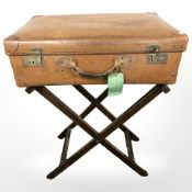 A luggage stand and vintage tan leather luggage case