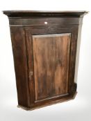 A George III oak corner cabinet,