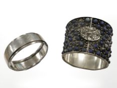 A Chinese white metal tapering cuff bangle set with lapis lazuli cabochons,