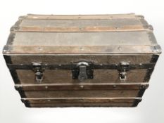 A wooden and canvas bound domed trunk,