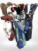 Four golf bags containing assorted irons and drivers including Walter Hagen, John Letters,