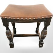 An oak and studded leather stool, width 44 cm.