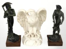 A resin figure of an eagle and a pair of patinated metal figures of a blacksmith and a harvester,