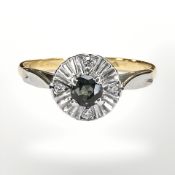An 18ct yellow gold ring illusion set with diamonds and a single blue / green sapphire, size O.