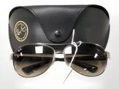 A pair of Ray-Ban sunglasses, with leather protective pouch.