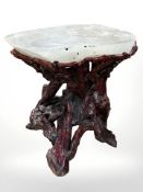 A Chinese red lacquered root wood occasional table with heavy polished jade-type hardstone inset