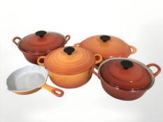 A group of Le Creuset enamelled and cast iron pans,