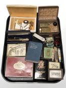 A group of tins, scale, folding knives, a Japanese Shakudo Ware cigarette box depicting Mount Fuji,