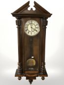 A walnut Vienna wall clock, with enameled dial, weight, pendulum and key, height 111 cm.