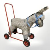 A vintage child's pushalong donkey toy, length 60 cm.