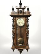 A walnut Vienna wall clock, with enameled dial, weights, pendulum and key, height 135 cm.