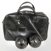 A set of four Jaques Jaquelite lawn boules, 5 and 1/16th, in leather carry bag.