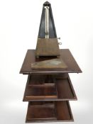 A small revolving mahogany three tier stand and a Maelzel metronome.