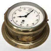 A Mercer brass circular ship's style timepiece, diameter 23 cm.