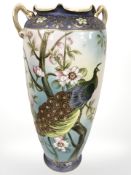 A Japanese export porcelain twin handled vase depicting a peacock, height 37 cm.
