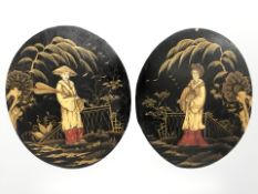 A pair of Japanese lacquered and gilt oval wooden panels depicting figures in traditional dress,