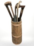 A coopered barrel containing several walking sticks,