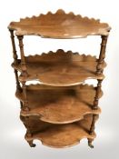 A Victorian walnut serpentine front four tier whatnot stand, width 76 cm.