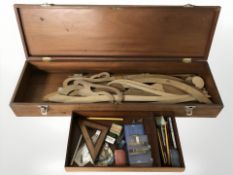 A draughtsman's box containing drawing utensils and various shapes and mouldings