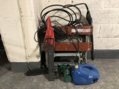 A Black and Decker work bench, petrol chain saw, electric hedge trimmer,