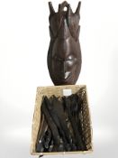A group of African carved wooden knives, two hand ornaments and a large mask.
