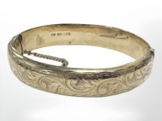 A 9ct yellow gold bangle with engraved decoration, diameter 60 mm x 57 mm internal.