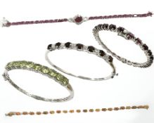 Three sterling silver bangles and two bracelets set with semi precious stones