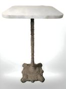 A granite topped bar table on cast iron support,