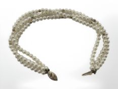 A three strand pearl bracelet studded with yellow gold and with 14ct gold clasp, length 20 cm.