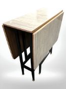 A 1960s melamine drop leaf dining table, overall 122 cm L x 76 cm W x 76 cm H.