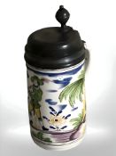 A pewter-mounted faience tankard decorated with a musician, bearing initials 'GHM' and date 1798,