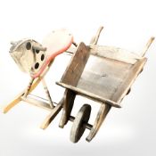 An antique child's wheelbarrow and a small rocking horse