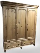 A modern pine Victorian style triple door wardrobe,